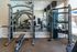 State-of-the-art gym with modern exercise equipment, mirrors enhancing the spacious feel, and bright natural lighting.