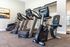 Modern fitness center with sleek exercise equipment including treadmills and stationary bike against a bright, inviting atmosphere.