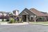 Charming community building with rustic stone facade and landscaped garden featuring a striking deer sculpture.