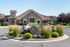 Charming apartment exterior with rustic stonework, surrounded by lush landscaping and a picturesque water feature.