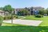 Charming apartment complex with lush green lawns, a basketball court, and mature trees for serene outdoor living.