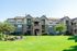 Charming apartment complex with lush green landscaping and spacious balconies.