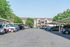 Inviting apartment complex with ample parking and lush greenery, featuring charming architecture and a serene atmosphere.