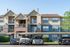 Charming apartment complex with a welcoming, modern facade and ample parking spaces, surrounded by lush greenery and clear blue skies.
