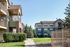 Charming residential community with modern townhouses surrounded by lush greenery and a well-maintained path, ideal for tranquil living.