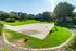 Vibrant apartment community with lush green lawns and a sunlit basketball court, perfect for active outdoor living.