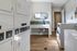 Modern laundry room with sleek washers and dryers, elegant tile flooring, and a stylish backsplash.
