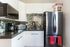 Modern kitchen with sleek stainless steel appliances, stylish mosaic backsplash, and elegant white cabinetry.
