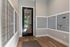 Modern apartment mailroom featuring sleek mailboxes and a stylish black door with a view of green outdoor space.