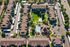 Aerial view of a vibrant apartment complex featuring lush green spaces, a sparkling swimming pool, and well-maintained pathways, creating a welcoming residential atmosphere.