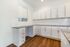 Modern kitchen with sleek white cabinetry, granite countertops, and warm hardwood flooring, perfect for culinary enthusiasts.