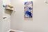 Bright utility room with modern decor, featuring a sleek abstract painting and neatly organized shelf.