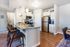 St. George, UT, Townhomes with In-Unit Washer and Dryer - Grayhawk Apartments at River's Edge - White Kitchen With Granite Island, Bar Seating, Stainless Steel Appliances, And Pendant Lights.