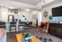 Chic living and dining area with modern decor, featuring a cozy seating setup, stylish dining table, and an open kitchen with sleek appliances and pendant lighting.
