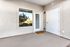 Inviting apartment entrance with a charming welcome mat, bright sunlight through blinds, and a sleek modern design.