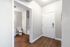 Inviting entryway with stylish wooden floors leading to a modern bathroom, showcasing sleek design and functionality.
