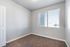 Bright, cozy room with plush carpet and a large window, perfect for natural lighting and contemporary living.