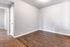 Inviting apartment interior featuring elegant hardwood flooring and plush carpet transition, highlighted by soft natural light.