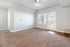 Bright and spacious room with plush carpet, modern ceiling fan, and access to a private balcony through glass doors.