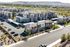 Modern apartment complex with stylish architecture surrounded by picturesque landscapes, featuring ample parking and lush greenery.