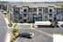 Modern apartment complex with lush landscaping, ample parking, and scenic hilltop views.
