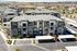 Modern apartment complex featuring well-maintained landscaping, multiple stories, and ample parking, set against a scenic hillside backdrop.