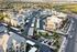 Aerial view of modern apartment complex with landscaped gardens, ample parking, and scenic surroundings, perfect for comfortable living.