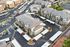 Aerial view of a modern apartment complex featuring well-maintained buildings, ample parking spaces, and lush landscaping.