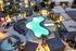 Luxurious apartment complex with a glowing resort-style pool, surrounded by palm trees and cozy cabanas, perfect for relaxing evenings.