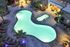 Luxurious night view of a glowing resort-style pool with surrounding lounge chairs and beautiful palm trees, perfect for relaxation and entertainment.