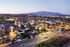 Charming apartment complex at dusk with illuminated buildings and mountain views, offering a serene and picturesque residential setting.