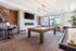 Bright and modern recreation room featuring a stylish pool table, large flat-screen TV, and cozy seating area with elegant decor.
