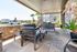 Inviting outdoor patio area with cozy seating, lush greenery, and a sleek modern design, perfect for relaxation and entertaining.