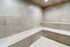Modern steam room with elegant beige tiles and built-in seating for relaxation.