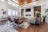 Three-Bedroom Townhomes in St. George, UT - Grayhawk Apartments at River's Edge - Modern Resident Lounge With Vaulted Wood Ceiling, Statement Chandelier, Fireplace, And Seating Areas.