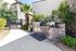 Inviting outdoor patio with stone grill area, lush greenery, and modern amenities for perfect alfresco dining.