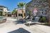 Luxurious apartment complex with a stylish stone exterior, featuring a relaxing swimming pool area surrounded by palm trees and comfortable lounge chairs.