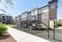 Modern apartment complex with a vibrant outdoor playground and lush greenery.