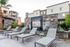 Modern apartment complex with cozy lounge area, featuring stylish reclining chairs and elegant stone water feature, perfect for relaxation and leisure.