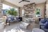 Chic outdoor patio with modern stone fireplace, cozy seating, and vibrant pillow accents offering a stylish setting for relaxation.