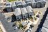 Aerial view of a modern townhouse complex showcasing stylish architecture and well-maintained landscaping with ample parking space.