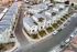 Modern suburban neighborhood with stylish multi-story townhouses, landscaped greenery, and ample parking along a curved street.