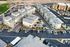 Aerial view of a modern apartment complex featuring neatly arranged townhouses with ample parking and landscaped surroundings for a serene living experience.