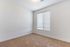 Bright, cozy room featuring soft carpet flooring and a large window with elegant blinds, perfect for a peaceful retreat.