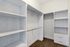 Spacious walk-in closet with built-in shelving and hanger rods, perfect for organized storage solutions.