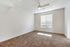 Inviting bedroom with plush carpeting, large window with blinds allowing natural light, and a modern ceiling fan for comfort and style.