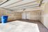 Spacious and bright garage featuring dual white doors, sleek concrete flooring, and ample natural light.