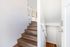 Bright and inviting staircase with modern wooden steps and sleek white walls, leading to an open upper level, perfect for contemporary living.