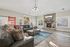 Elegant living room with a cozy stone fireplace, sleek leather sofas, and chic decor, featuring large windows that invite natural light.