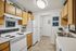 Charming kitchen with natural wood cabinets, modern appliances, and stylish decor accents, perfect for culinary enthusiasts.